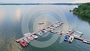 Aerial top view of boats near wooden pier at lake