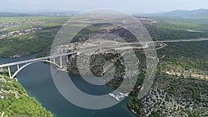 Aerial top view of bridge above the sea with cars and trucks. Autostrada bridge with traffic over Krka river in Croatia, Europe.