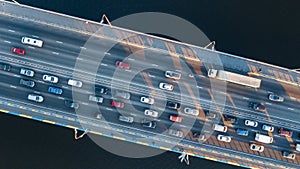 Aerial top view of bridge road automobile traffic jam of many cars from above, city transportation