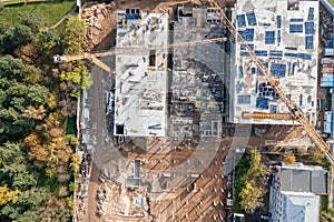 Aerial top view of building site with construction cranes