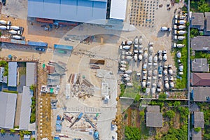 Aerial top view of busy industrial factory or plant. Construction site workers with cranes working. Top view of development high