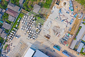 Aerial top view of busy industrial factory or plant. Construction site workers with cranes working. Top view of development high