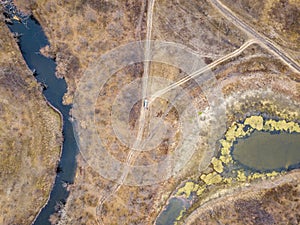 Aerial top view of the car on the road off road in countryside on a rainy day f