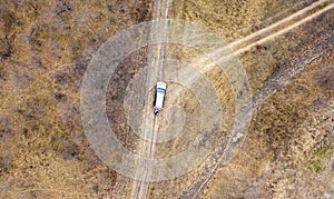 Aerial top view of the car on the road off road in countryside on a rainy day f