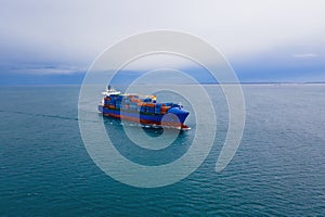 Aerial top view of cargo ship carrying container for export goods