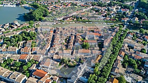 Aerial top view of Castelnaudary residential area houses roofs, streets and canal with boats from above, old medieval town