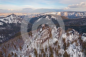 Aerial top view city Krasnoyarsk Russia taiga forest and rocks of stolby sanctuary, winter sunset