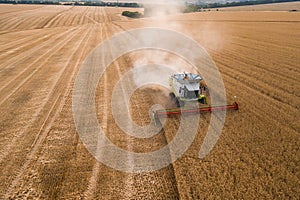 Aerial top view of combine harvester working on wheat field