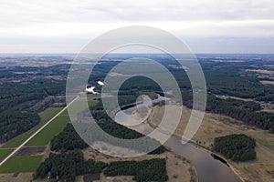 Aerial top view, countryside spring panorama of quiet river and forest on sunny evening day