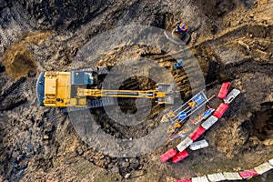 Aerial top view on crawler excavator digging ground for overhaul road. Construction machinery performs energy intensive heavy work