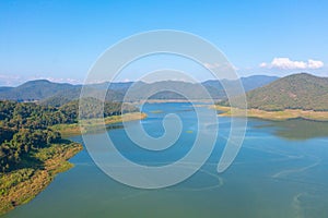 Aerial top view of a dam with forest trees, lake, river, mountain hills in travel and environment concept. Nature landscape