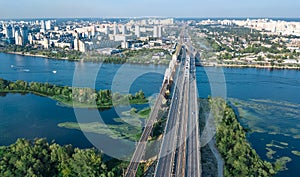 Aerial top view of Darnitsky bridge, Dnieper river and cityscape from above, city of Kiev