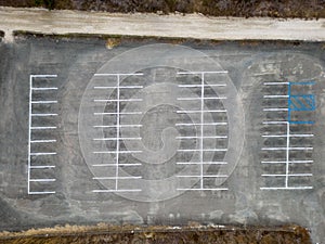 Aerial top view directly above an empty, paved parking lot on a cloudy day