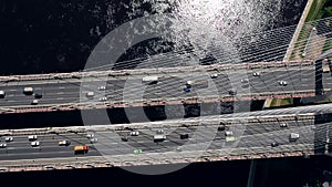 Aerial or top view from drone of concrete bridge with asphalt road or highway over big river with city car traffic