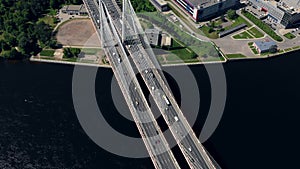 Aerial or top view from drone of concrete bridge with asphalt road or highway over big river with city car traffic