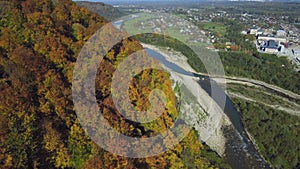 Aerial, top view from Drone: flying over the mountain with forest and river.