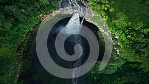 Aerial top view drone rise up over Coban Sriti waterfall, Indonesia