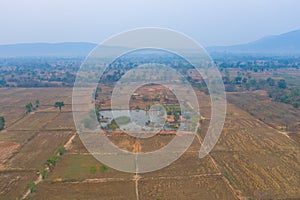 Aerial top view of dry paddy rice, brown agricultural fields in countryside, mountain hills valley in Asia, Chiang Mai, Thailand.