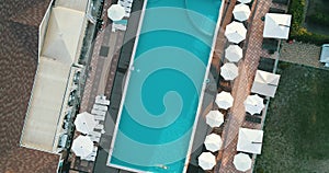 Aerial top view of family in swimming pool from above, happy mother and kids swim on inflatable ring donuts and have fun