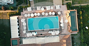 Aerial top view of family in swimming pool from above, happy mother and kids swim on inflatable ring donuts and have fun