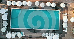 Aerial top view of family in swimming pool from above, happy mother and kids swim on inflatable ring donuts and have fun