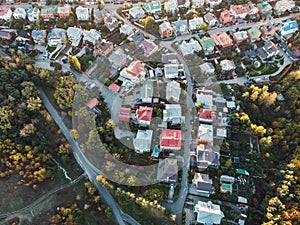 Aerial top view from flying drone above suburban neighborhood with residential houses and streets