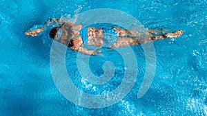 Aerial top view of girl in swimming pool water from above, tropical vacation concept