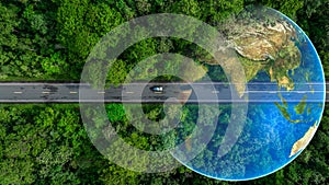 Aerial top view of green electric vehicle car driving over straight forest road, EV car electric vihicle car on forest road with