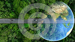 Aerial top view of green electric vehicle car driving over straight forest road, EV car electric vihicle car on forest road with