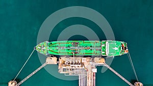 Aerial top view of green oil tanker cargo vessel under cargo ope
