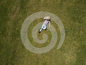 Aerial top view Happy man lying on the green grass. Outdoor recreation