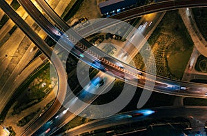 Aerial top view of Highway road junctions. Rush hour traffic on multiple highways in city at night.