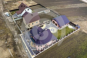 Aerial top view of house shingle roof on background of green lawn and colorful paved yard with geometrical abstract pattern