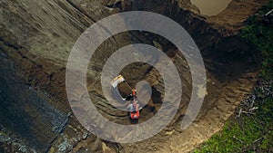 Aerial top view hyper lapse excavator loads dump truck with earth