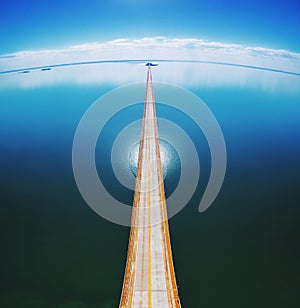 Aerial top view of a long highway bridge above a river. photo
