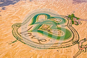 Aerial top view of love lake and sand desert, Heart shaped lakes in Al Qudra in Dubai, United Arab Emirates or UAE.  A new tourist photo