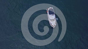 Aerial top view of a luxury white yacht and relaxing people. Clip. Concept of summer vacation, beautiful sail boat