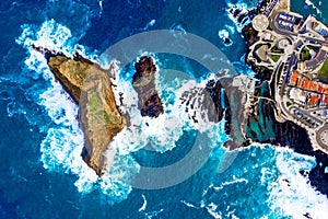 Aerial top view of Madeira island with Atlantic ocean waves crashing to the cliffs