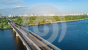 Aerial top view of Metro railway bridge with train and Dnieper river from above, city of Kiev, Ukraine