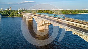 Aerial top view of Metro railway bridge with train and Dnieper river from above, city of Kiev, Ukraine