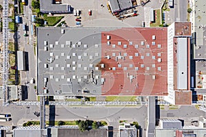 Aerial top view of modern industrial building roof with ventilation and skylights