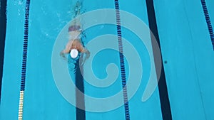 Aerial top view, muscular male swimmer in swimming pool. professional man athlete swims in butterfly style. Water