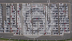 Aerial top view of new cars parking for sale stock lot row, dealer inventory import and export business commercial worldwide,