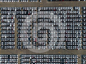 Aerial top view of new cars parking for sale stock lot row, dealer inventory import and export business commercial worldwide,