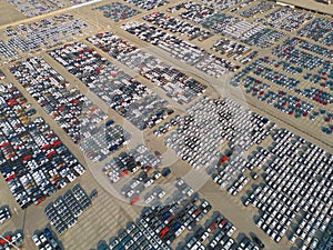 Aerial top view of new cars parking for sale stock lot row, dealer inventory import and export business commercial worldwide,