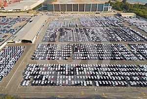 Aerial top view of new cars parking for sale stock lot row, dealer inventory import and export business commercial worldwide,