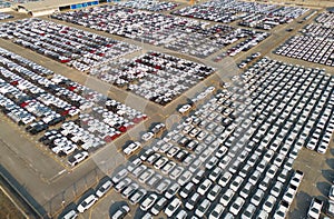 Aerial top view of new cars parking for sale stock lot row, dealer inventory import and export business commercial worldwide,