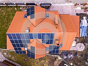 Aerial top view of new modern residential house cottage with blue shiny solar photo voltaic panels system on roof. Renewable