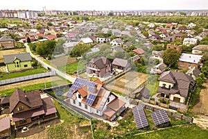 Aerial top view of new modern residential house cottage with blue shiny solar photo voltaic panels system on roof. Renewable