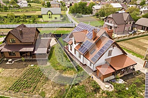 Aerial top view of new modern residential house cottage with blue shiny solar photo voltaic panels system on roof. Renewable